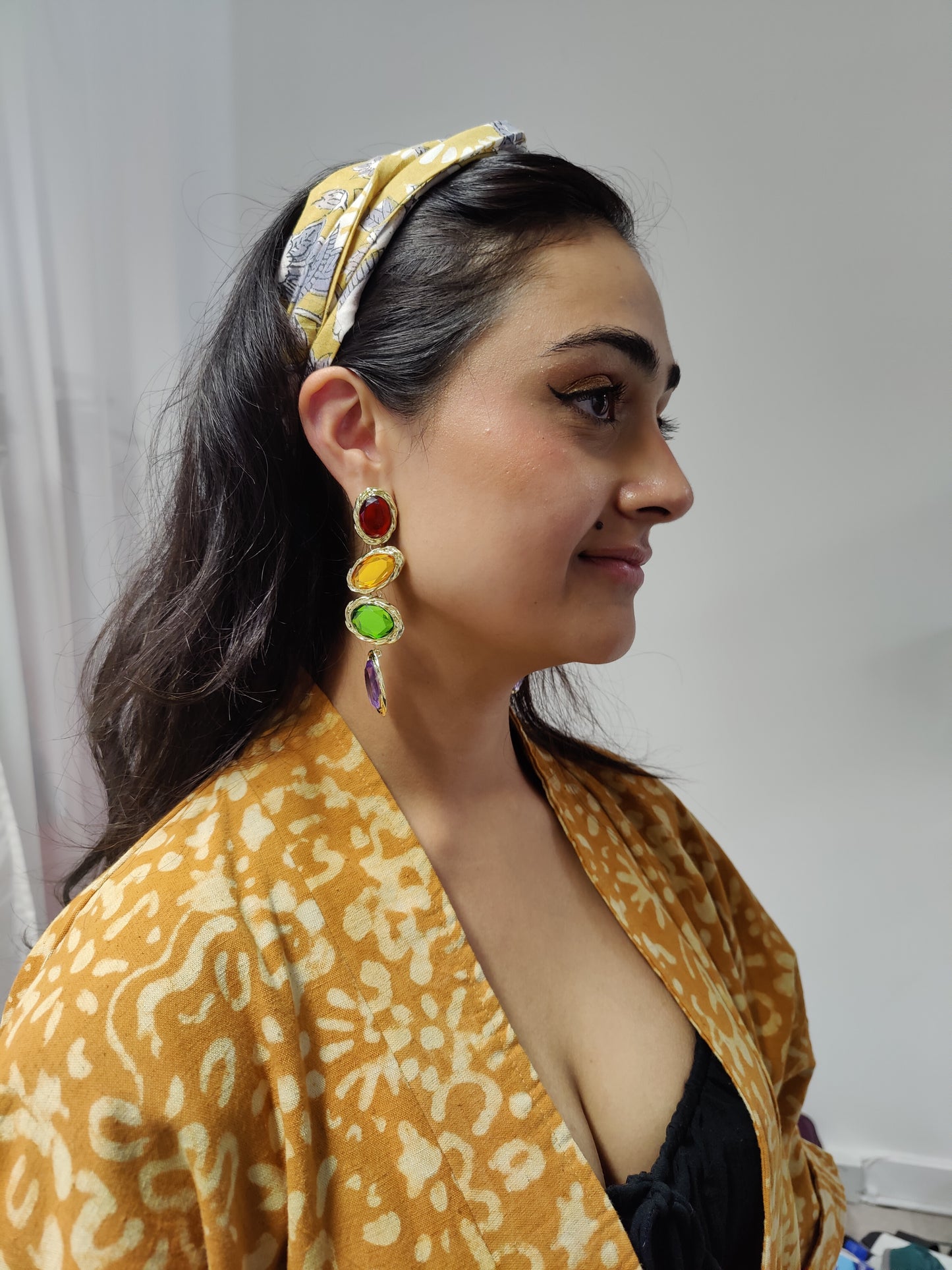 Model wearing mustard headband with statement earrings and kimono jacket